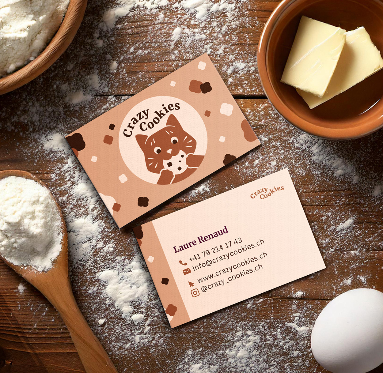 Carte de visites avec l'identité visuelle de Crazy Cookies sur un plan de travail de patissière